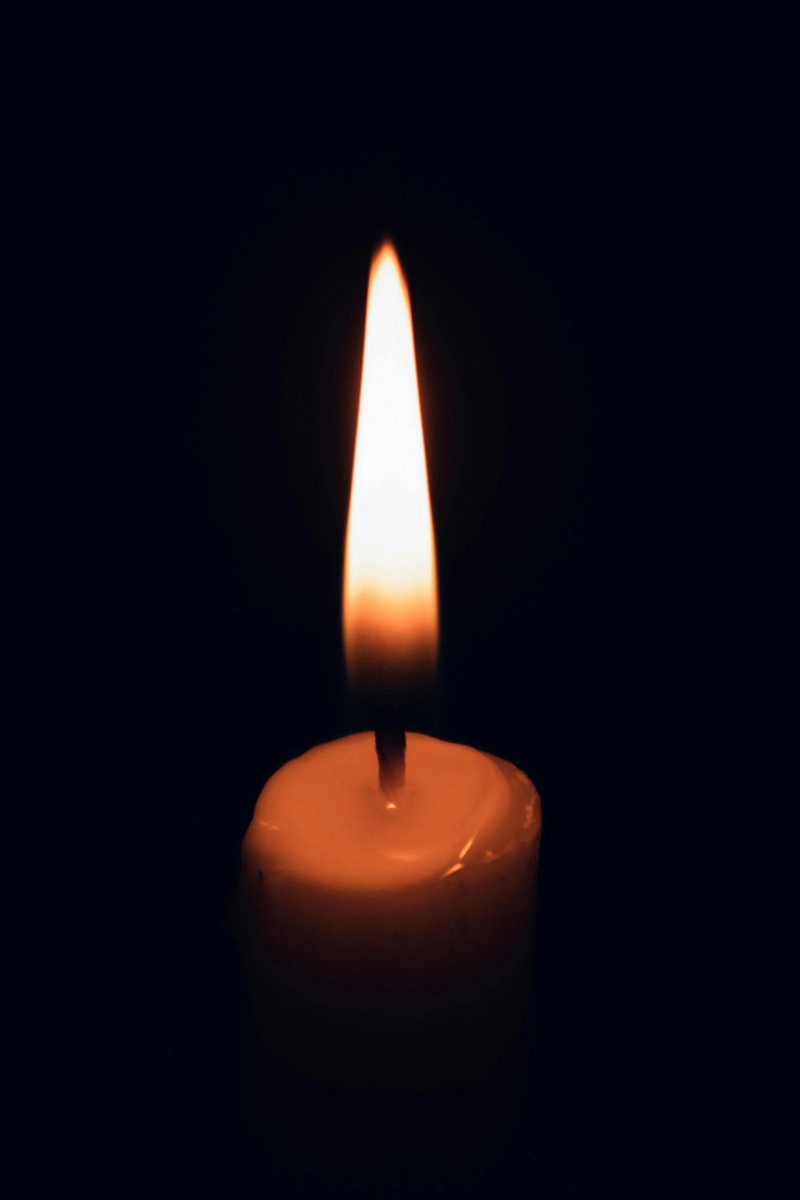 A single candle's warm glow — quiet, reverent end-of-life care