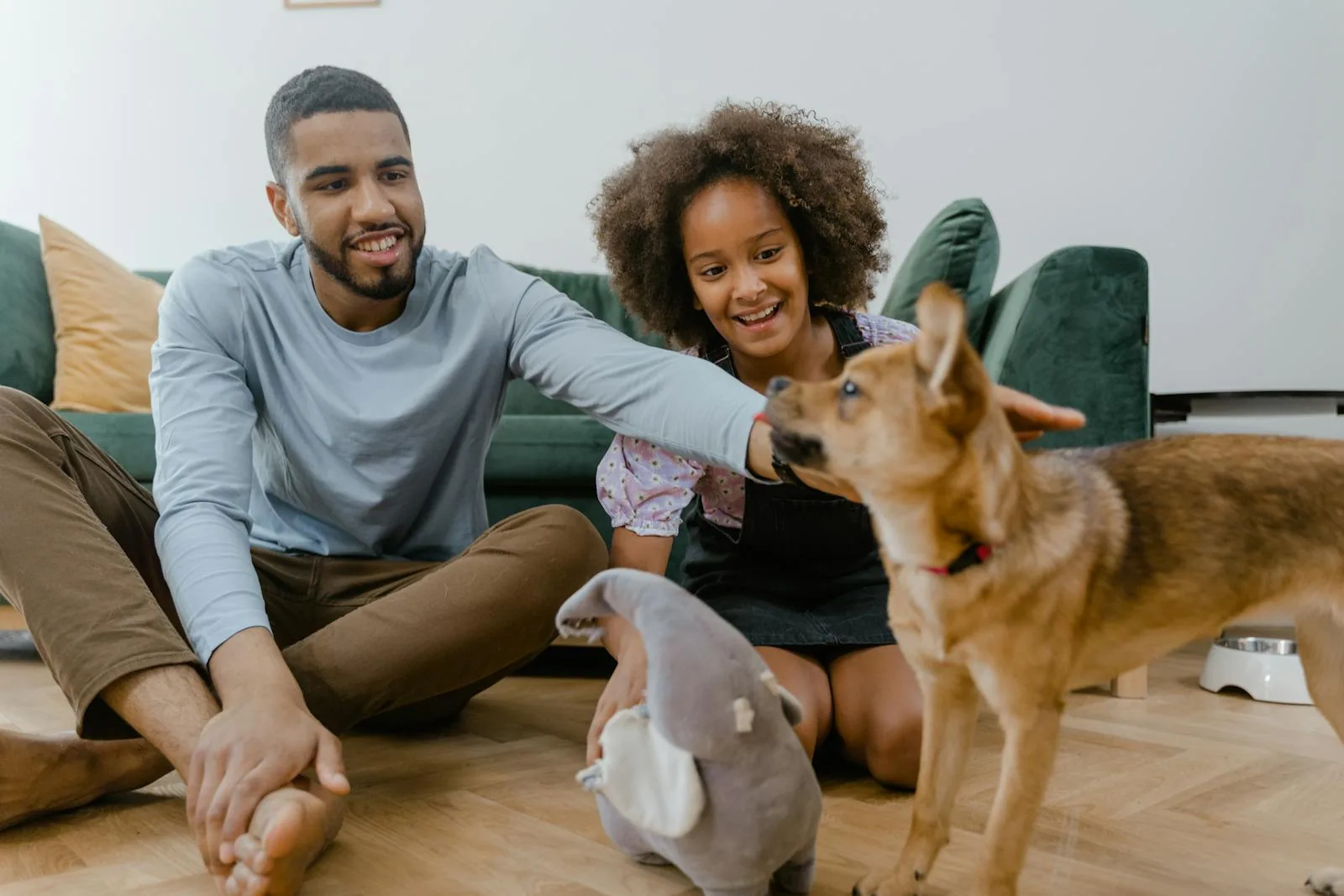 A man and his daughter spending quality time with their dog indoors &mdash; family-friendly veterinary care
